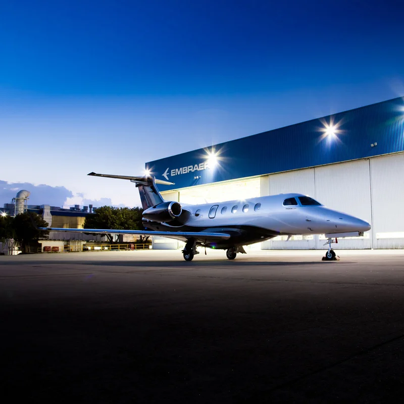 phenom 300 in front of Embraer hanger at night