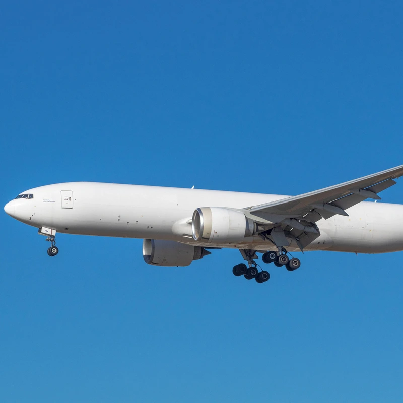 side view of white Boeing 777 in flight